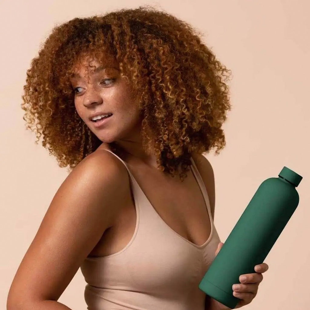 Woman holding olive 1L Beysis water bottle.