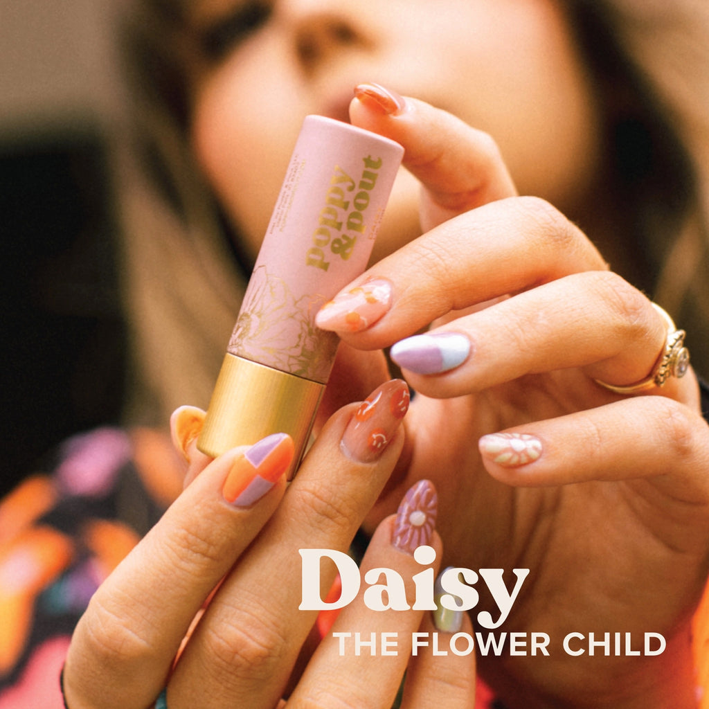 Woman holding Poppy & Pout Lip Tint Daisy.