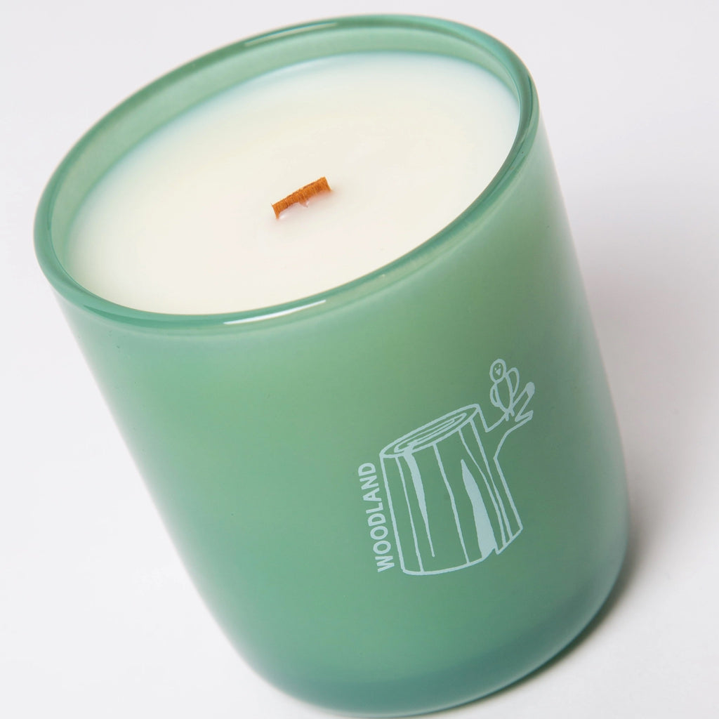 Woodland Essential Oil Coconut Soy Candle on surface.